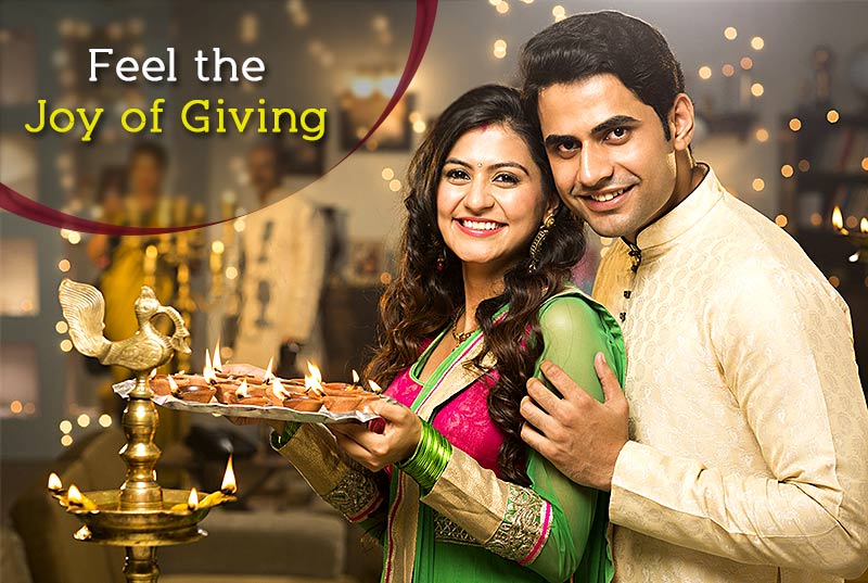 A couple celebrating the festival of Diwali with Diyas A couple celebrating the festival of Diwali with Diyas