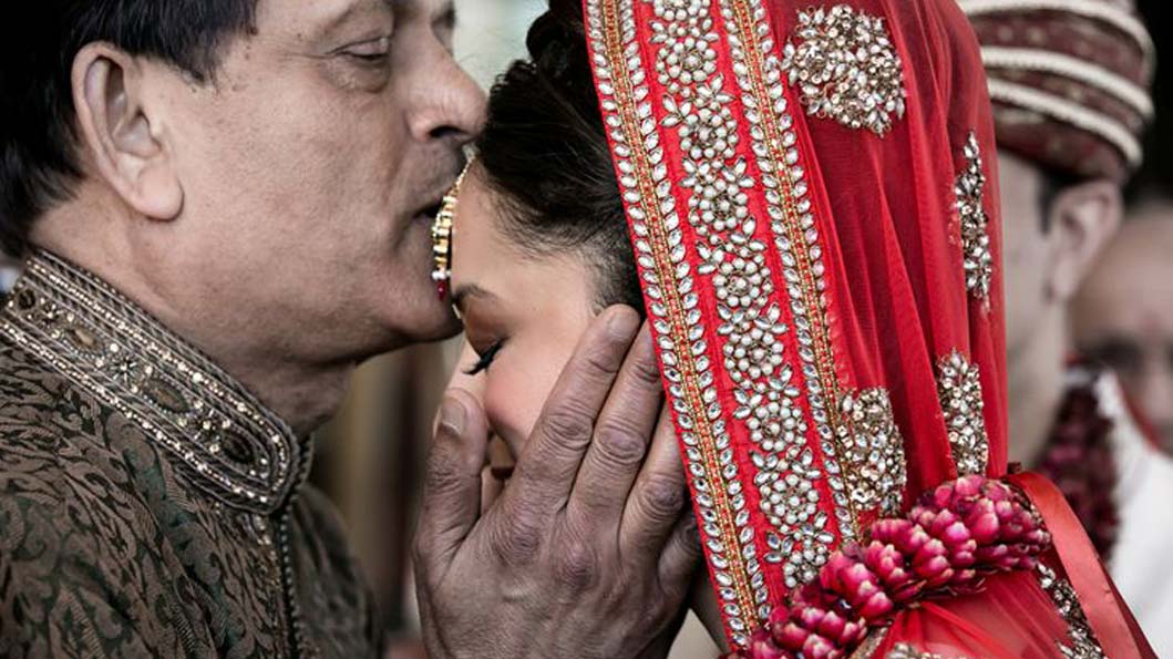 Father letting her daughter off his side with a kiss on her forehead Father letting her daughter off his side with a kiss on her forehead