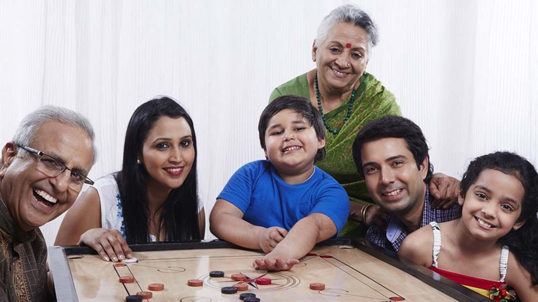 Family playing a carrom match together in appreciation of dad Family playing a carrom match together in appreciation of dad