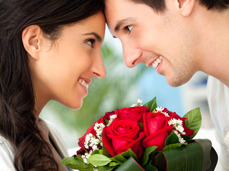 A beautiful couple with a bunch of red roses A beautiful couple with a bunch of red roses